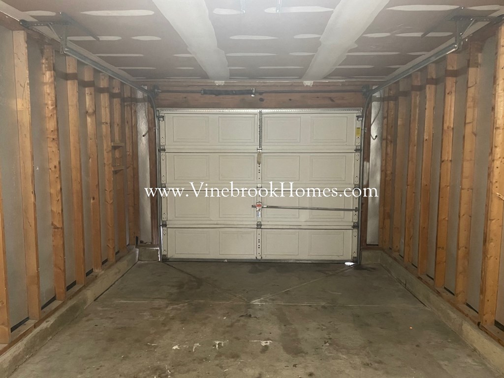 a garage with white doors and a concrete floor