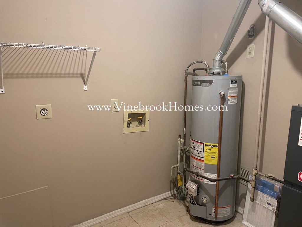 a boiler in the corner of a room next to a wall