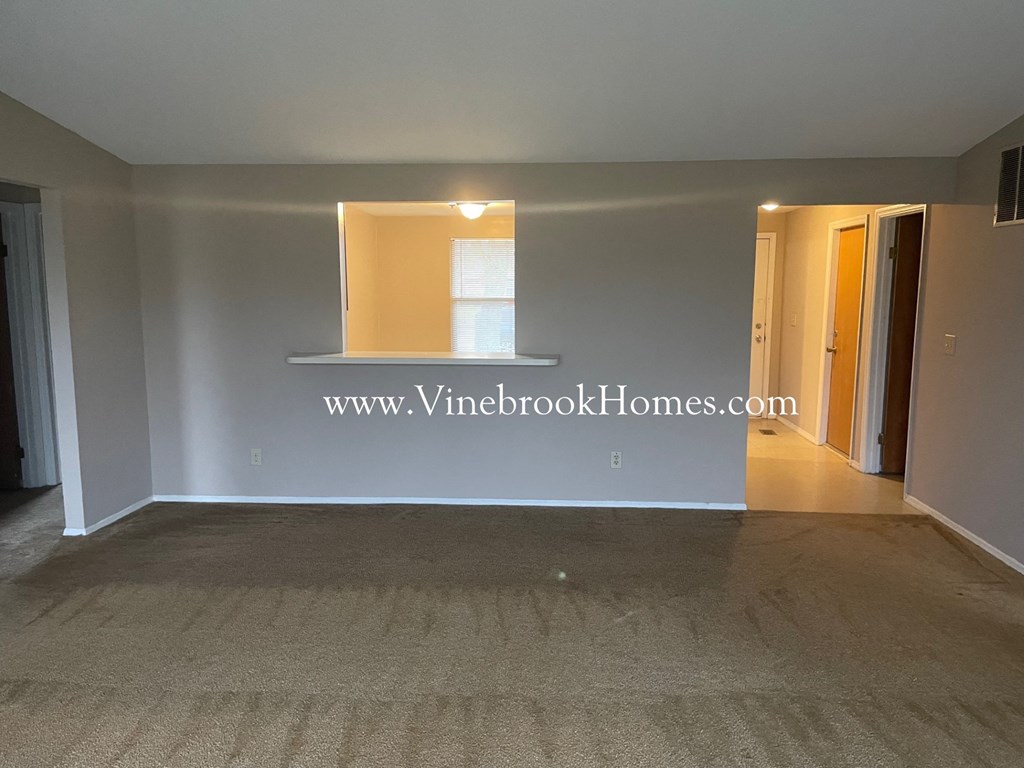 a living room with a white wall and a window
