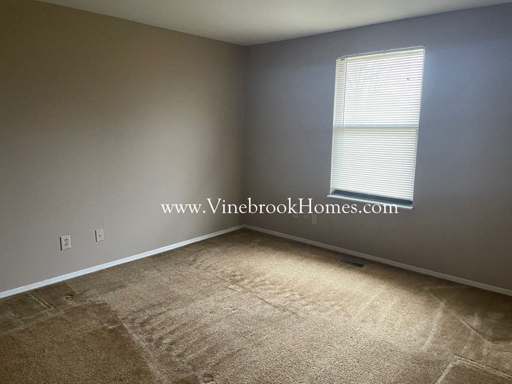 a small room with carpet and a window