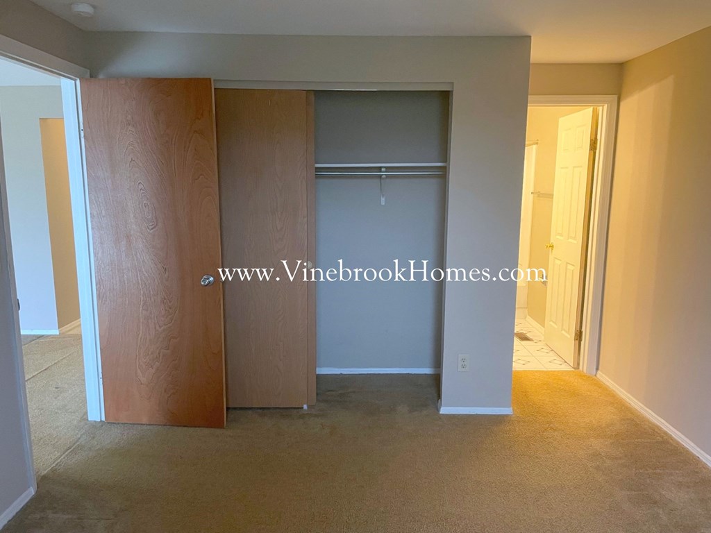 a closet in a living room with a mirrored closet door
