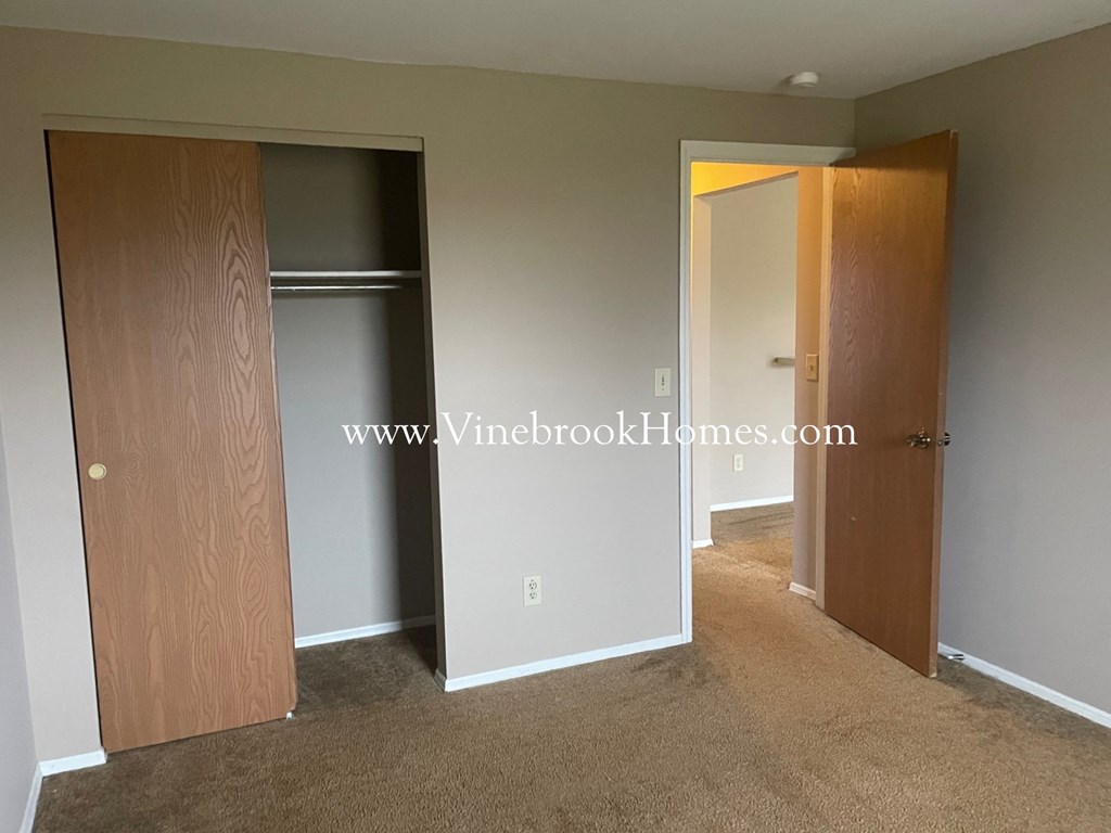 a bedroom with a closet and a door to a bathroom