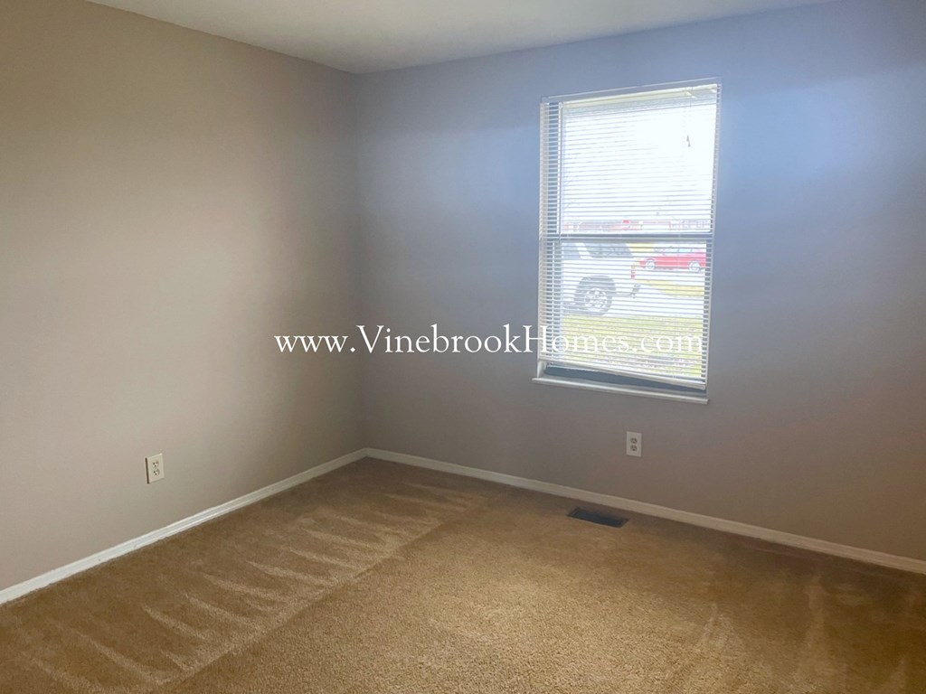 a small room with a window and a carpet