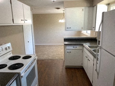 A kitchen with white cabinets and a stove top oven.