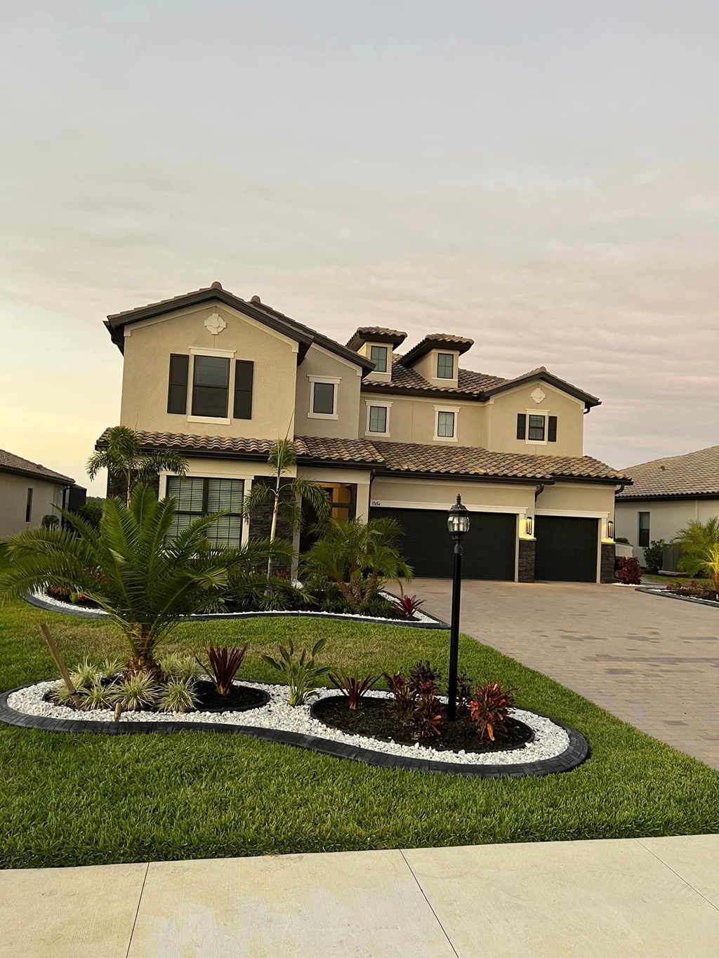 a house with a driveway and landscaping in front of it