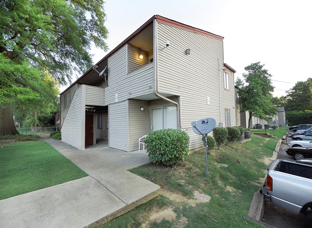 the side of a house with a driveway and a parking lot