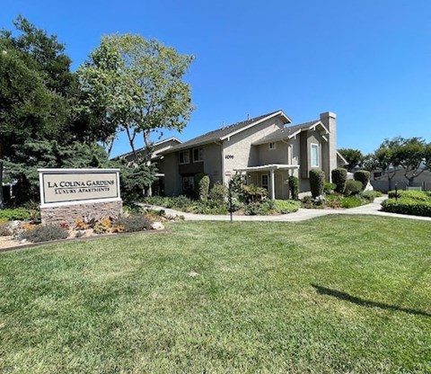 a lawn in front of a house with a sign