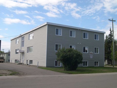 A grey building with a sign on the front.