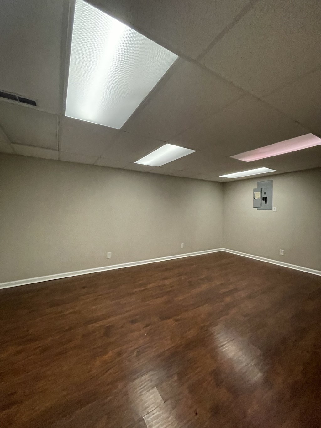 A room with wooden floors and a ceiling with lights.