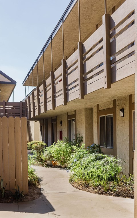 A building with a tan facade and a wooden fence.