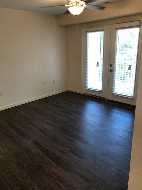 an empty living room with a wood floor and doors