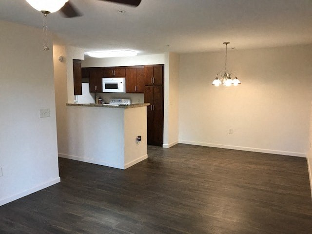 an empty living room and kitchen with wood flooring