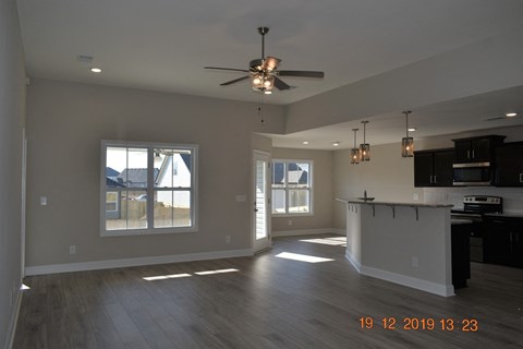 A spacious room with a ceiling fan and wooden flooring.