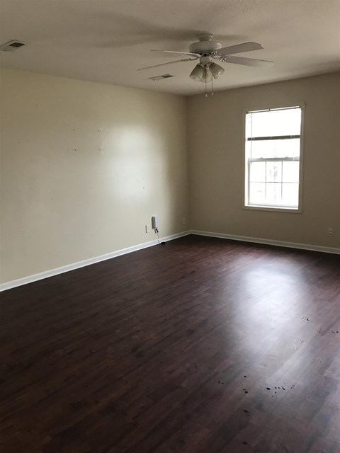 A room with a ceiling fan and a window.