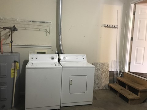 A white dryer and washer are sitting next to each other in a room.