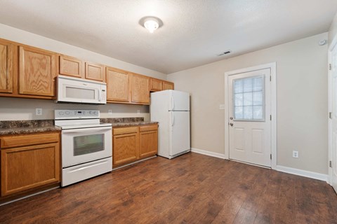 a kitchen with white appliances and wooden cabinets