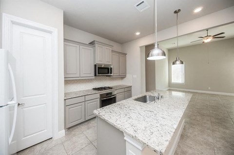 a kitchen with white cabinets and a counter top
