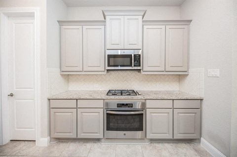 a kitchen with white cabinets and a counter top