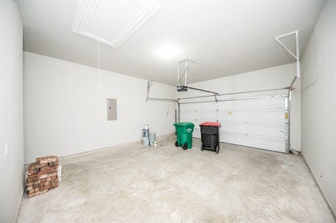 the garage is empty and has a white wall and a white garage door