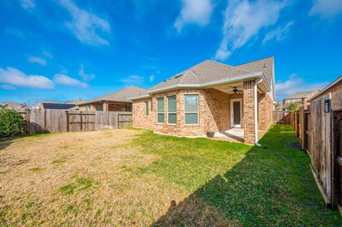 a brick house with a yard and a wooden fence