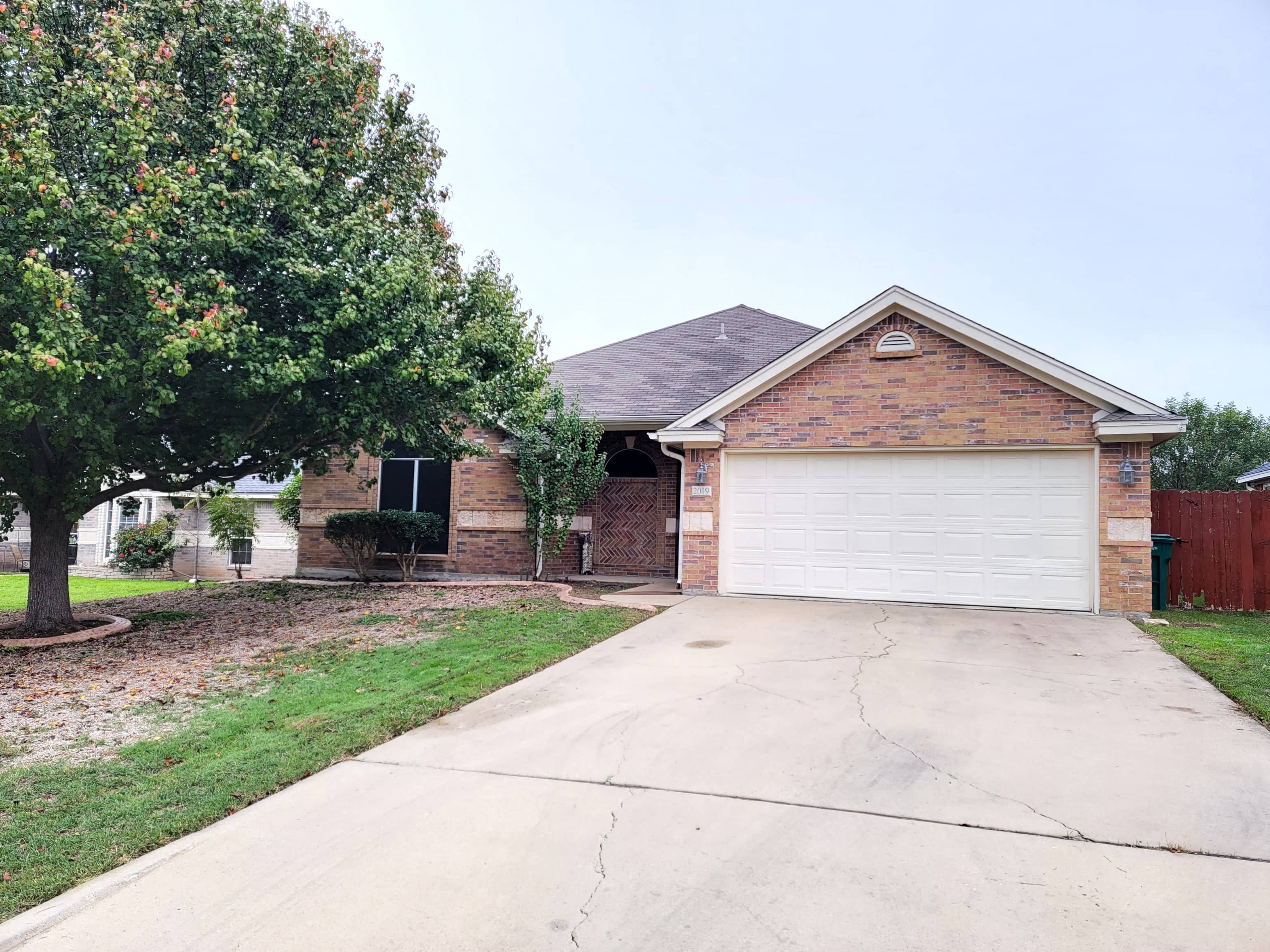 a small brick house with a white garage door