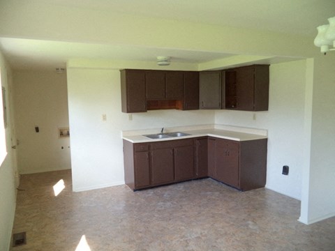 an empty kitchen with a sink and cabinets