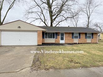 the front of a brick house with a white garage