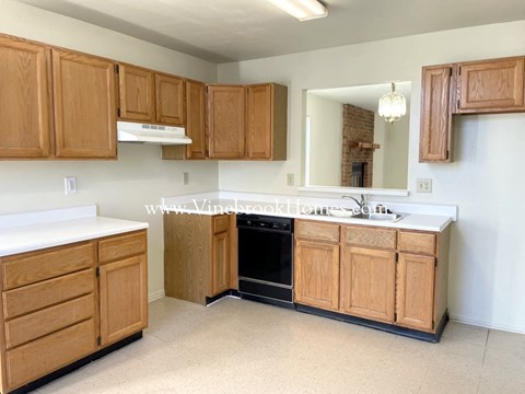 a kitchen with wooden cabinets and a sink and a mirror