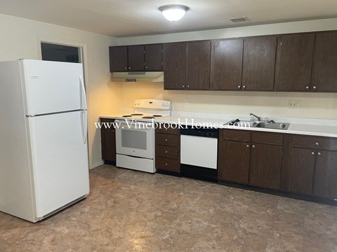 a small kitchen with white appliances and wooden cabinets