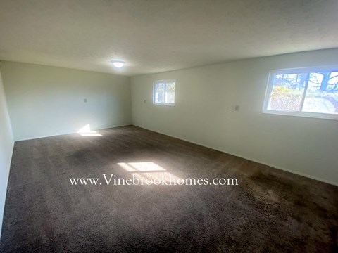 the living room of a house with a carpet and a window