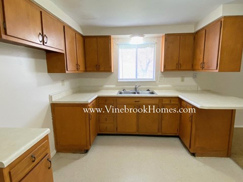 A kitchen with wooden cabinets and a sink.