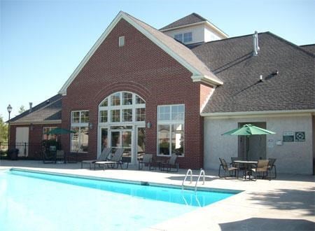 a swimming pool in front of a brick building