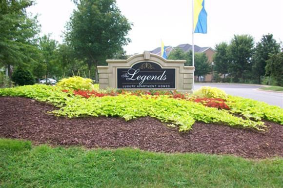 a garden of flowers in front of a sign