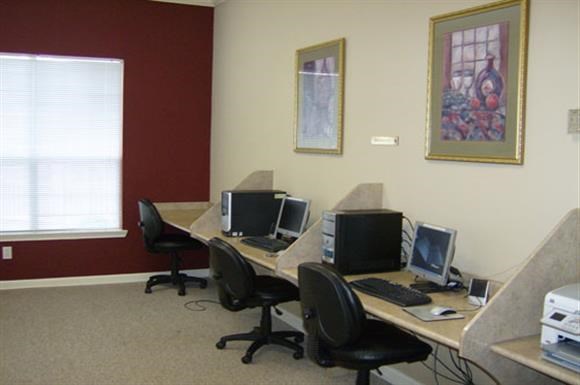 a room with three desks with computers on them