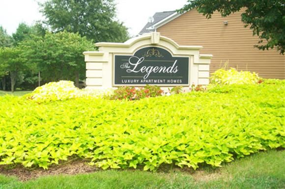 the legends sign in front of a garden of flowers