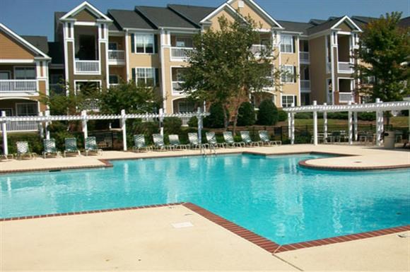 a large swimming pool in front of an apartment building