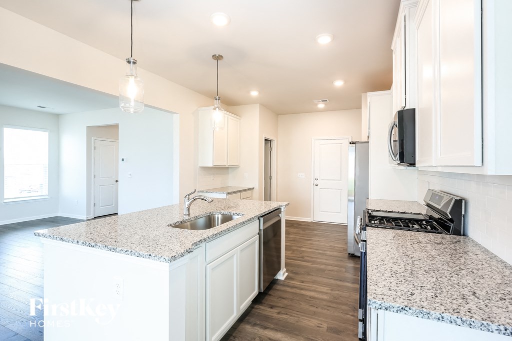 a kitchen with white cabinets and granite counter tops