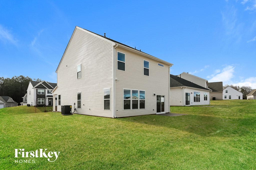 a white house with white siding on the side of a green lawn