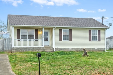 A house with a brown roof and a white fence.
