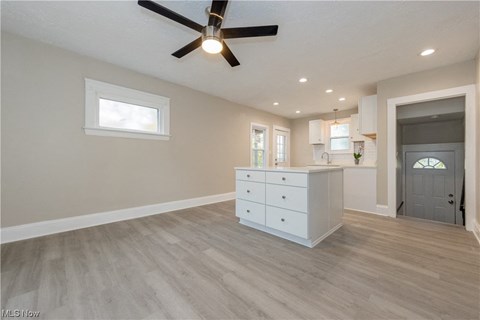 an open kitchen and living room with a ceiling fan