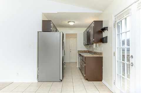 A kitchen with a refrigerator and microwave.