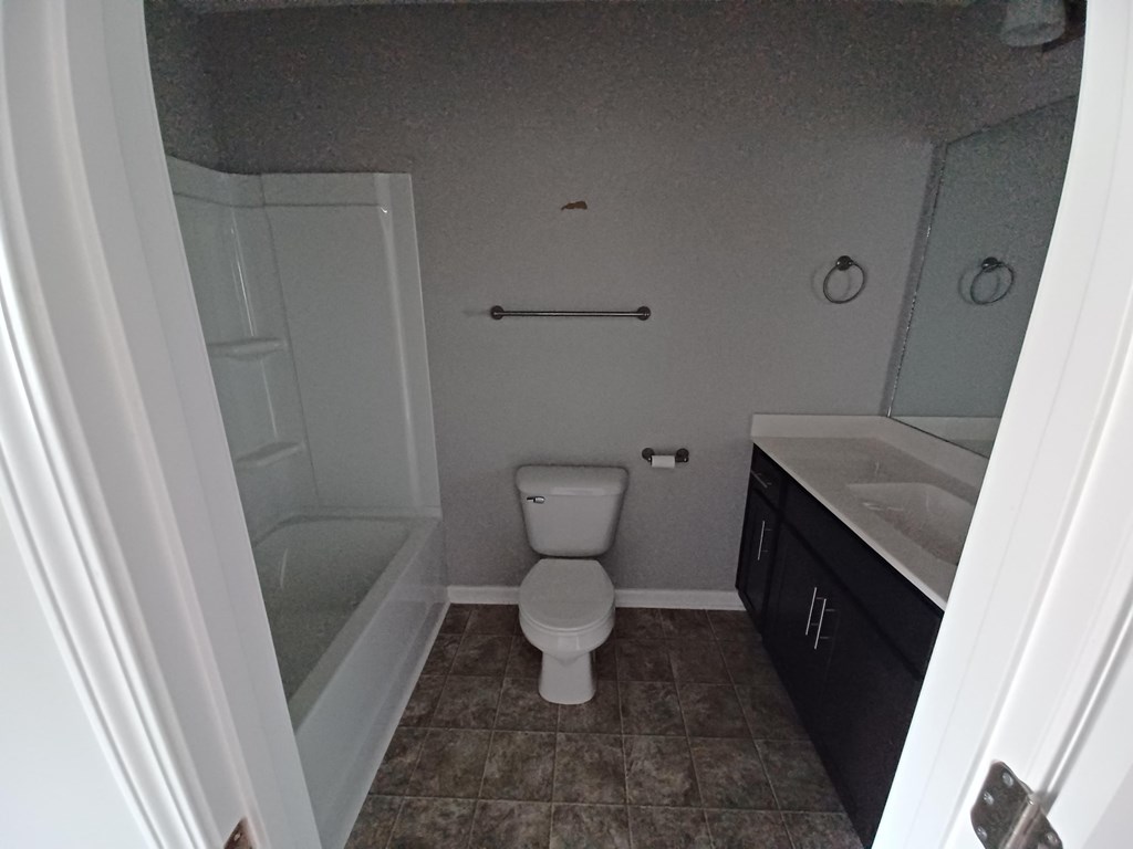 A white toilet in a bathroom with a white door.
