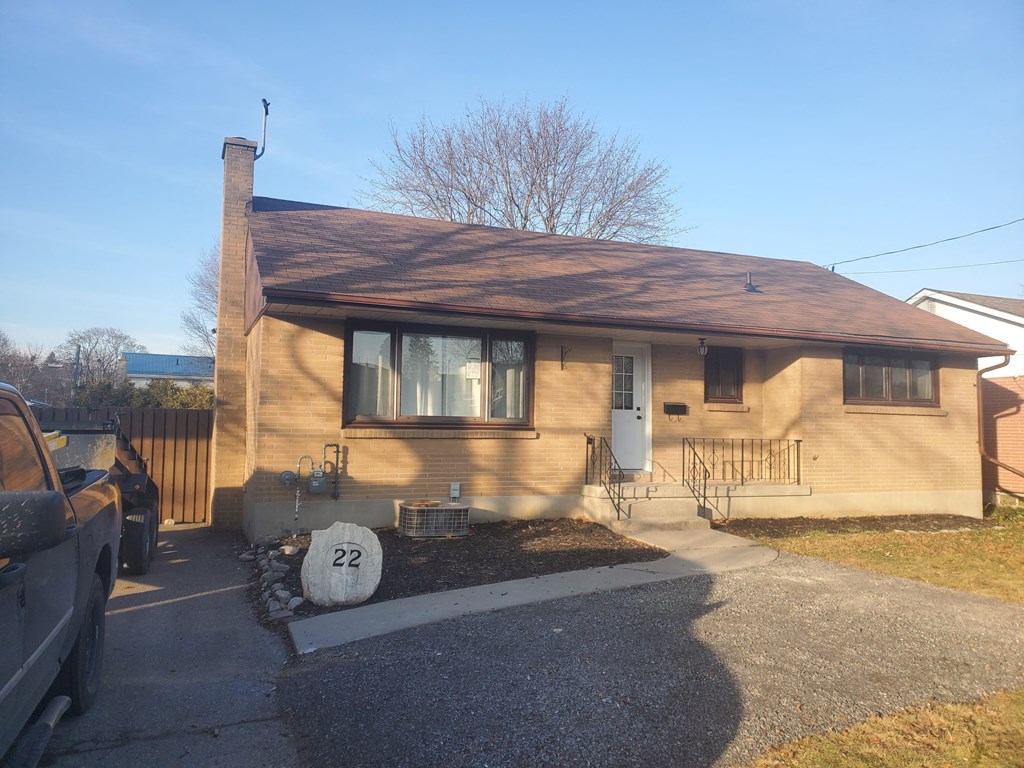a small house with a yard and a parking lot