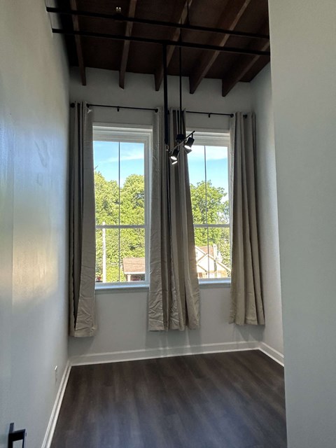a living room with two windows with curtains