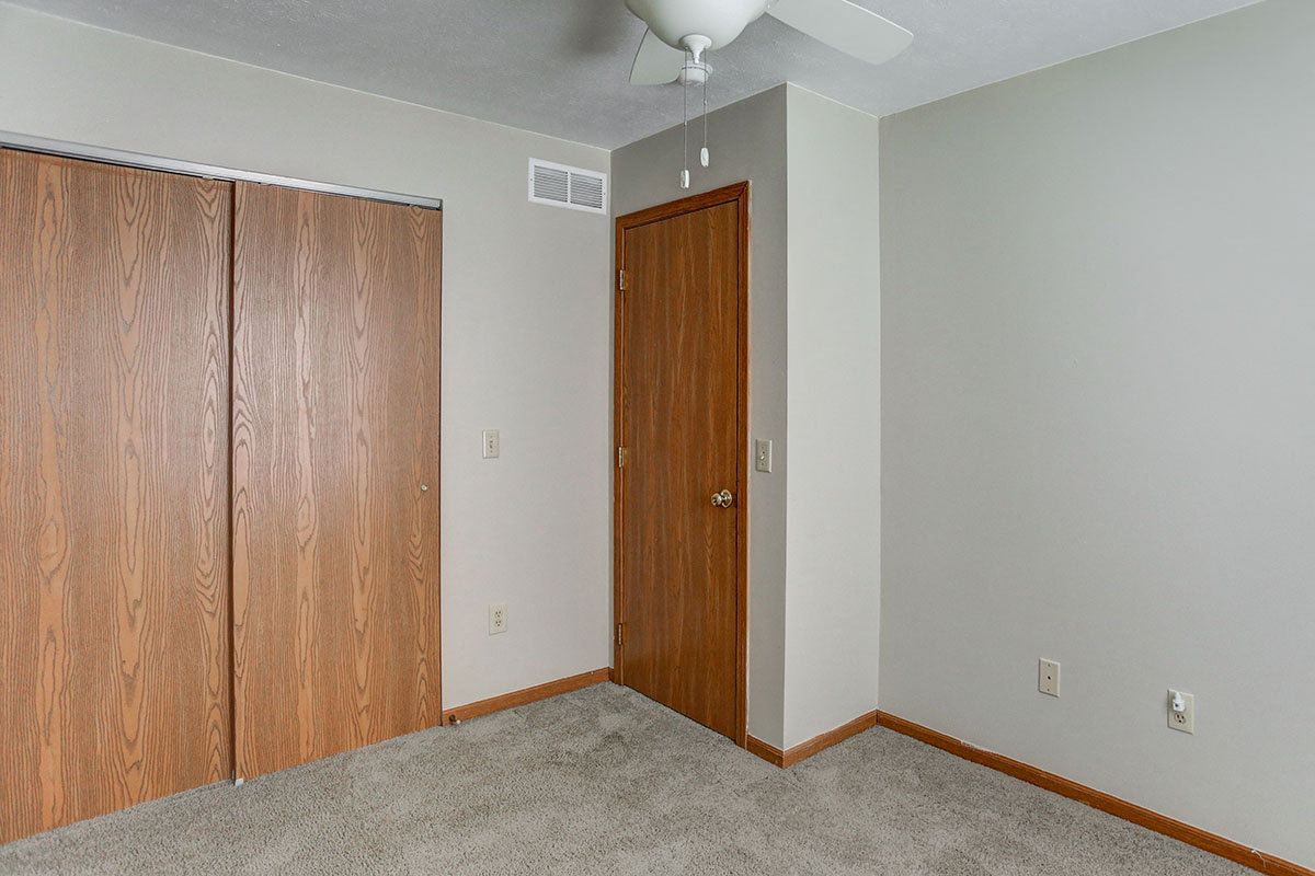a bedroom with a closet and a ceiling fan