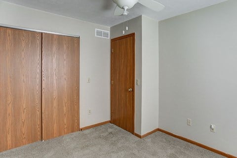 a bedroom with a closet and a ceiling fan