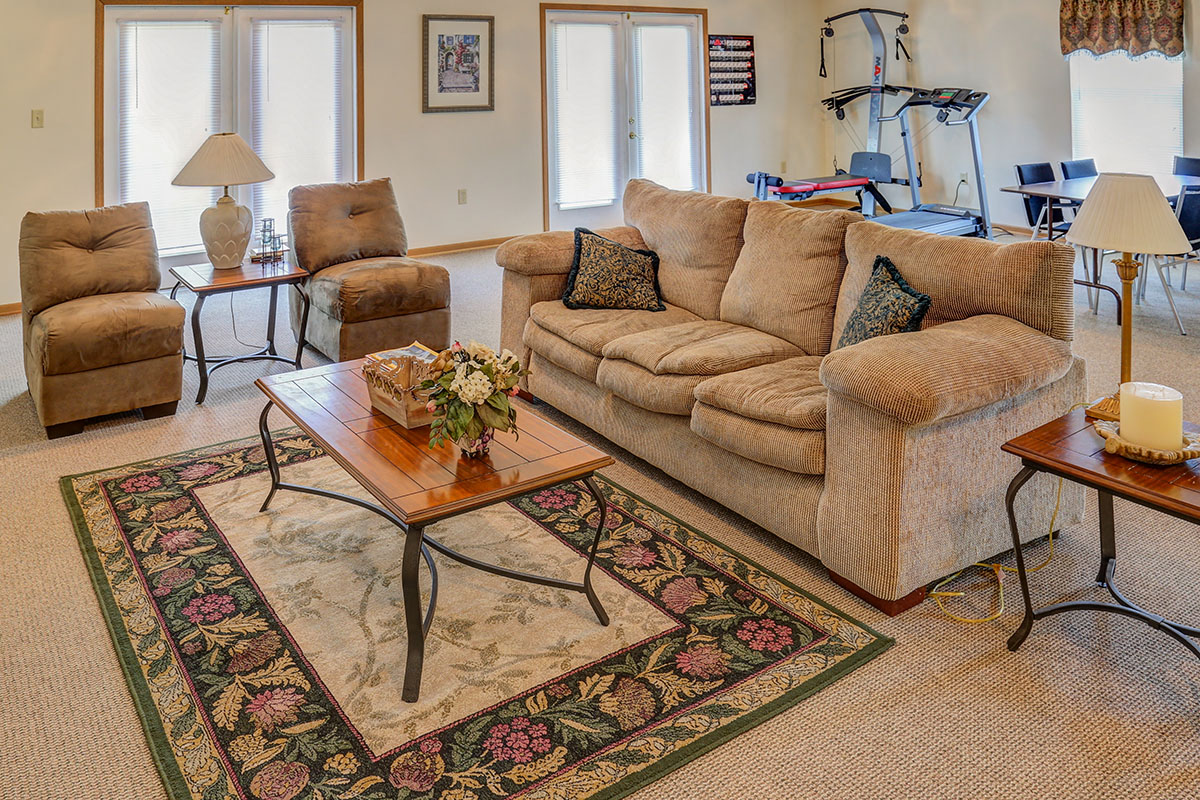 a living room with couches and chairs and a rug