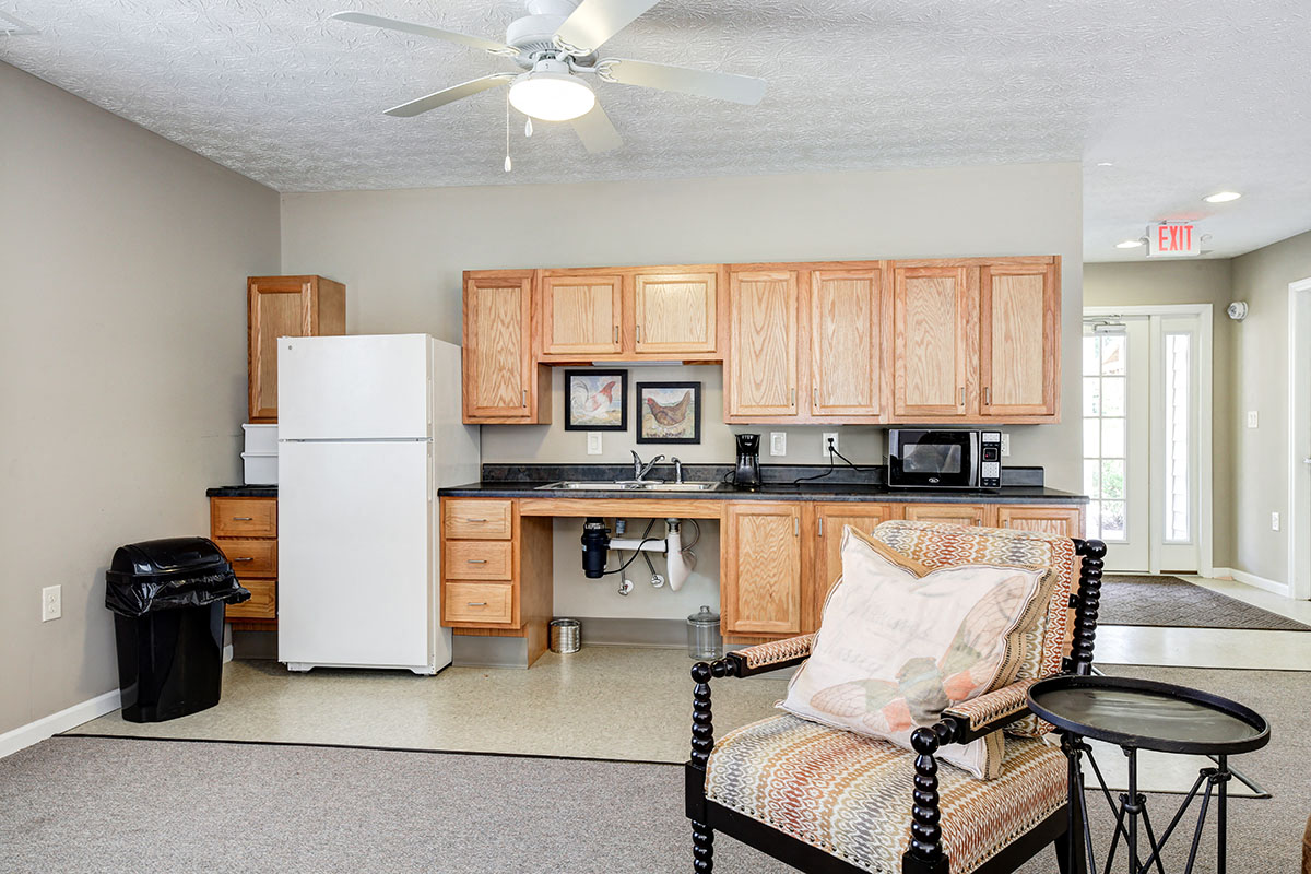a kitchen and living room with a refrigerator and a sink
