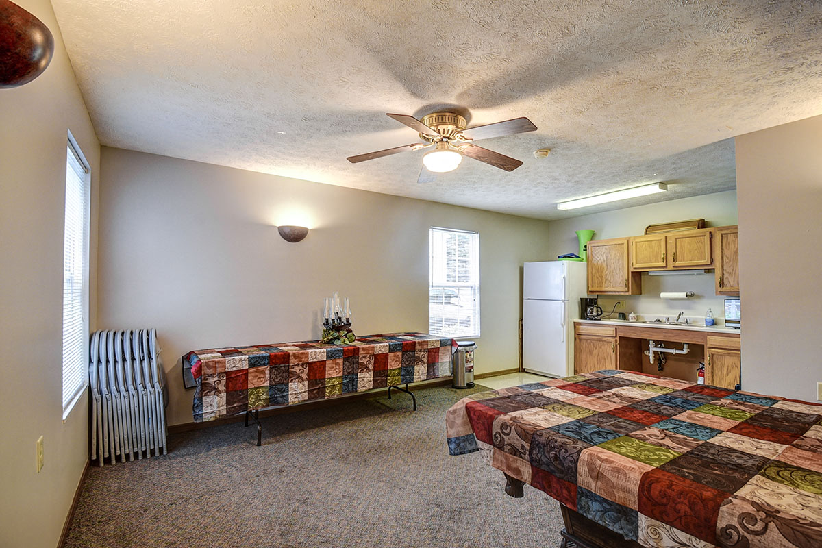 a bedroom with a bed and a ceiling fan