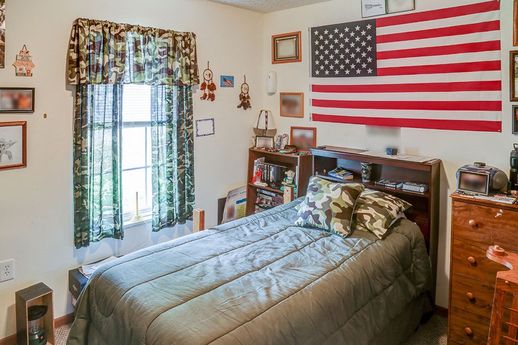 a bedroom with a bed and an flag on the wall